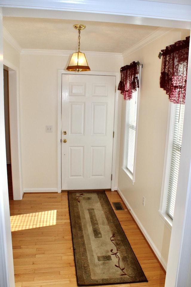 doorway to outside with crown molding and light wood-type flooring