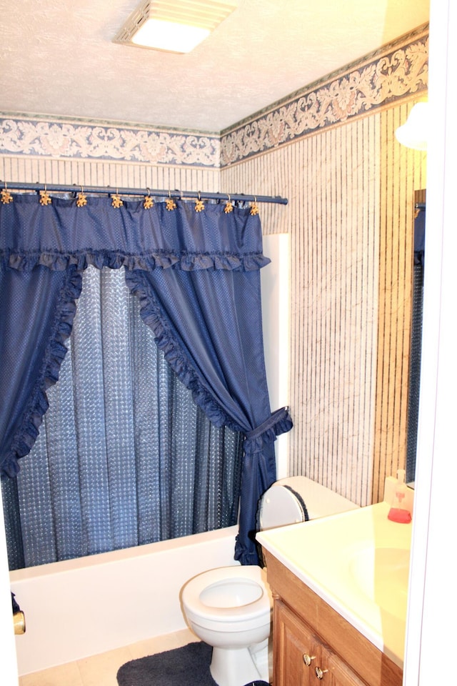 full bathroom featuring vanity, a textured ceiling, toilet, and shower / tub combo with curtain