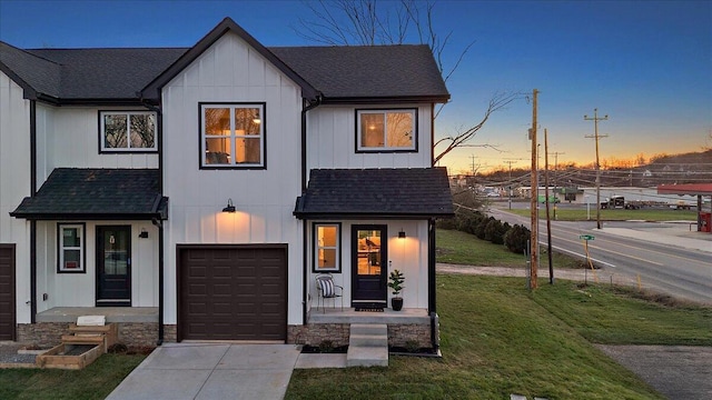 modern inspired farmhouse featuring a garage and a yard