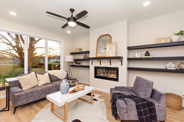 living room with ceiling fan and light hardwood / wood-style flooring