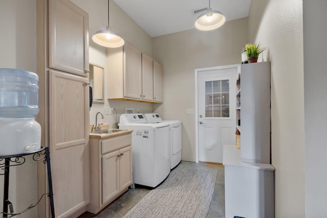 laundry room featuring cabinets, separate washer and dryer, and sink