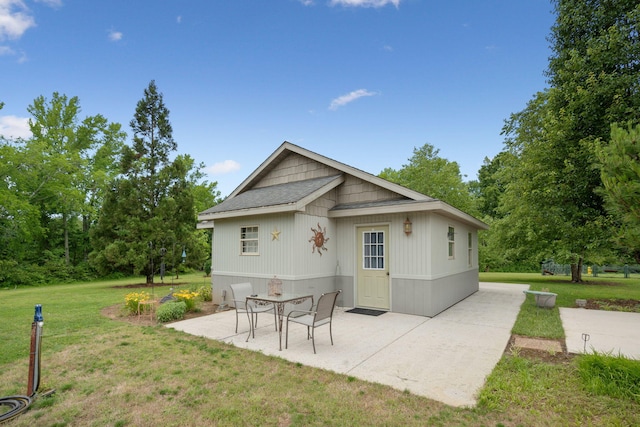 rear view of house featuring a patio and a lawn