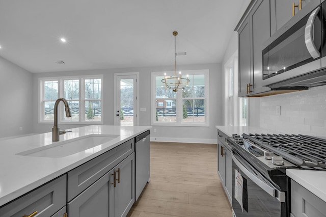 kitchen with gray cabinets, appliances with stainless steel finishes, and sink