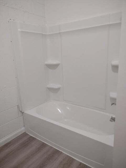 bathroom featuring bathtub / shower combination and hardwood / wood-style floors