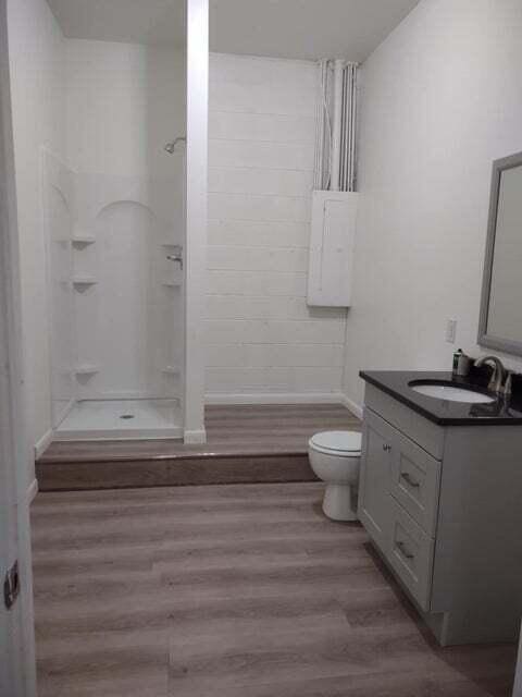 full bathroom featuring hardwood / wood-style flooring, vanity, bathing tub / shower combination, and toilet