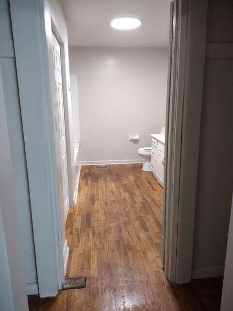 bathroom with hardwood / wood-style flooring, vanity, and toilet