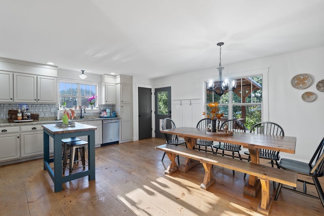 dining space featuring sink, a chandelier, and light hardwood / wood-style floors