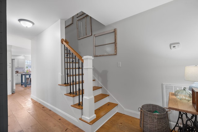 stairs featuring hardwood / wood-style flooring