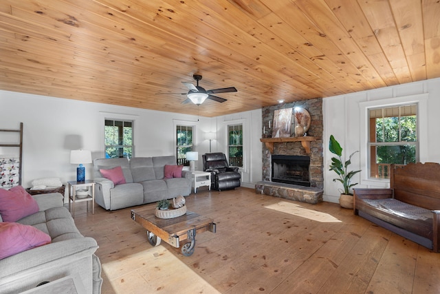 living room featuring hardwood / wood-style floors, wood ceiling, a fireplace, and ceiling fan