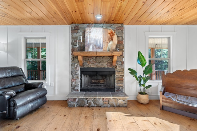 living area featuring wood ceiling, a fireplace, and light wood-type flooring