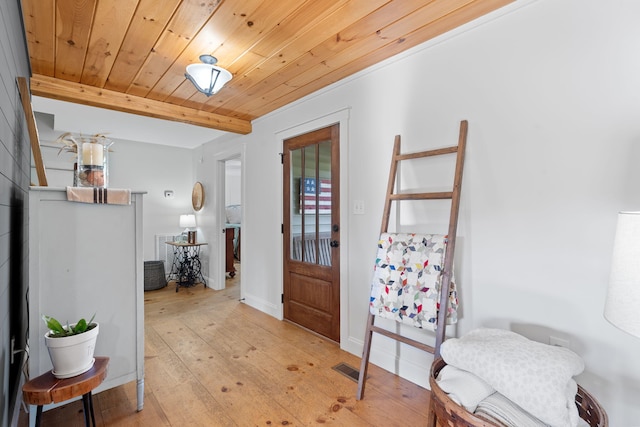 entryway featuring beam ceiling, light hardwood / wood-style flooring, and wooden ceiling