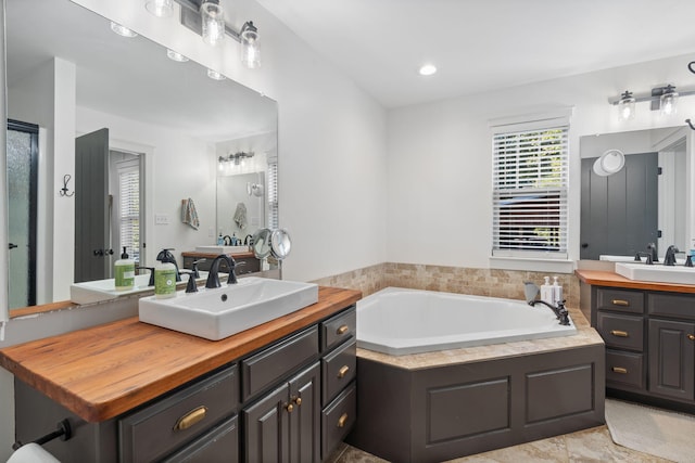 bathroom featuring vanity and a bath