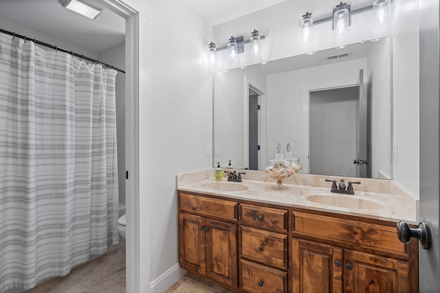 bathroom with tile patterned flooring, vanity, and toilet