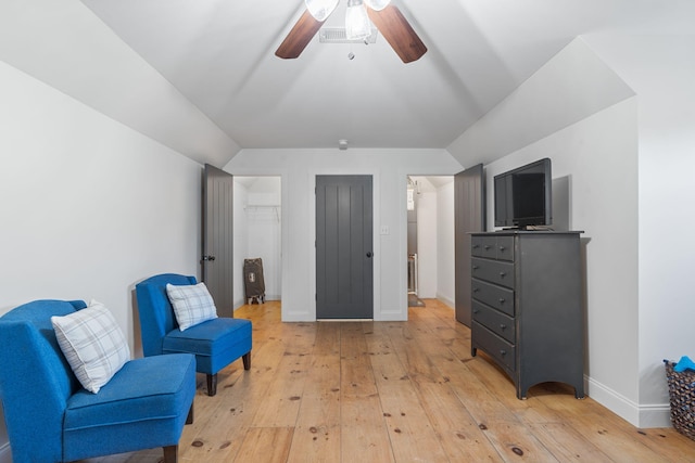 sitting room with vaulted ceiling, ceiling fan, and light wood-type flooring