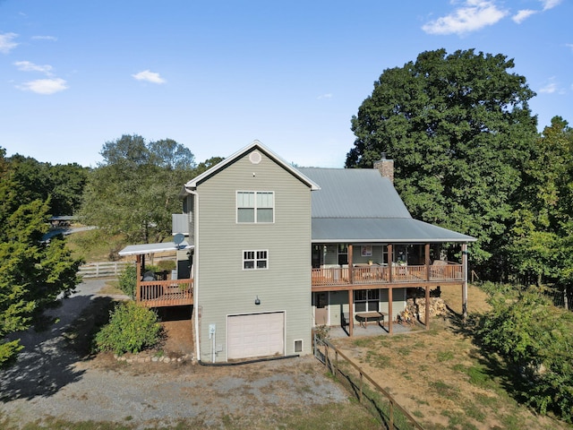 back of house with a garage and a deck