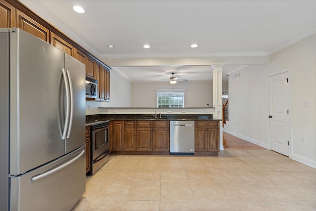 kitchen with light tile patterned flooring, stainless steel appliances, sink, and dark stone counters