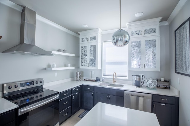 kitchen with sink, white cabinetry, hanging light fixtures, stainless steel appliances, and wall chimney range hood