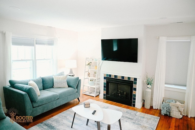 living area featuring visible vents, wood finished floors, and a fireplace