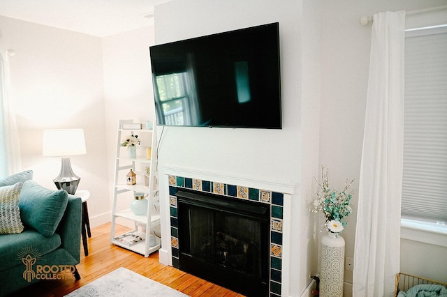 living area featuring wood finished floors and a tile fireplace