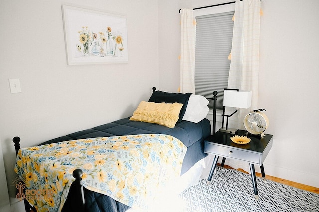 bedroom featuring baseboards and wood finished floors