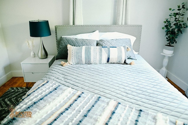 bedroom with wood finished floors and baseboards