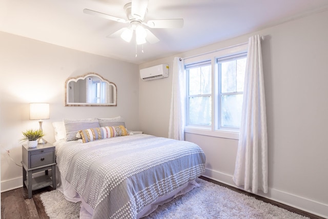 bedroom featuring ceiling fan, baseboards, wood finished floors, and a wall unit AC