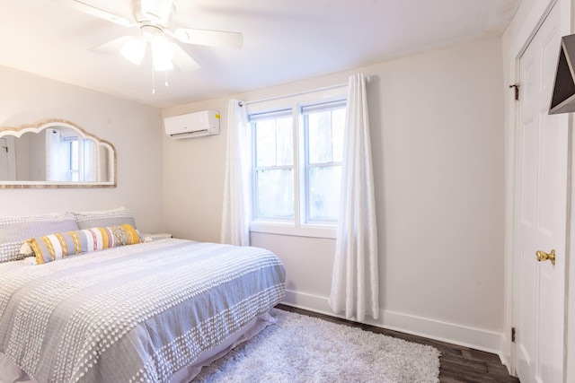 bedroom featuring baseboards, wood finished floors, a ceiling fan, and a wall mounted AC