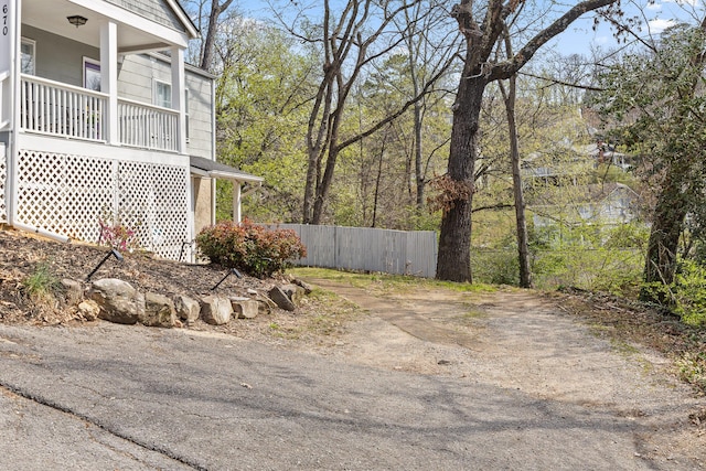 view of yard with covered porch and fence