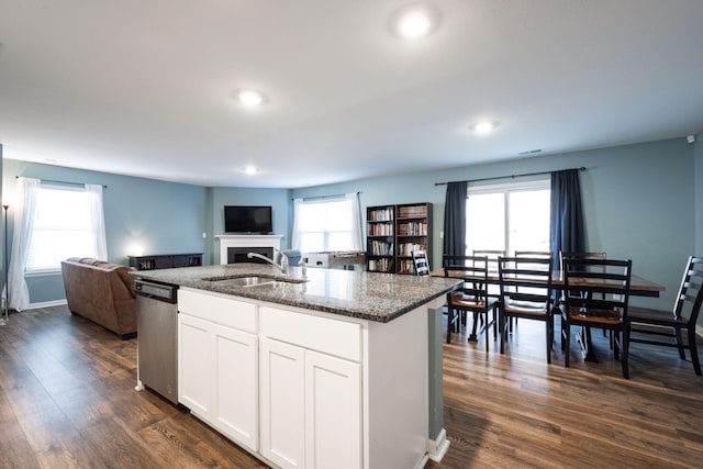 kitchen with sink, white cabinetry, a kitchen island with sink, dark stone countertops, and stainless steel dishwasher