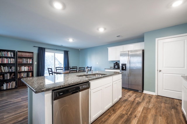 kitchen featuring sink, white cabinets, dark hardwood / wood-style flooring, stainless steel appliances, and a center island with sink