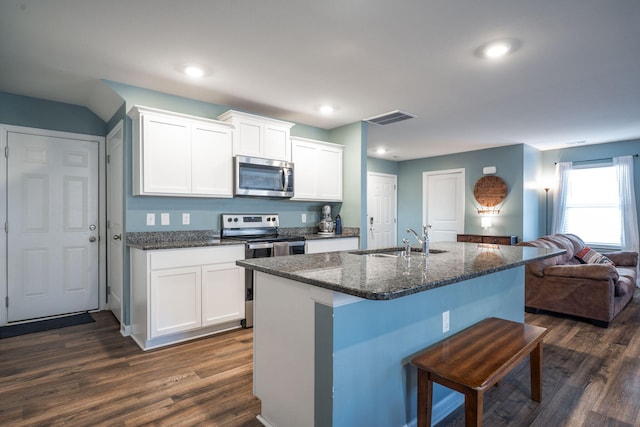 kitchen featuring stainless steel appliances, a kitchen island with sink, sink, and white cabinets