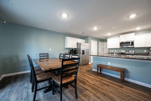 dining space featuring dark wood-type flooring and sink