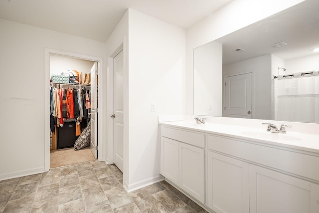 bathroom featuring a shower and vanity