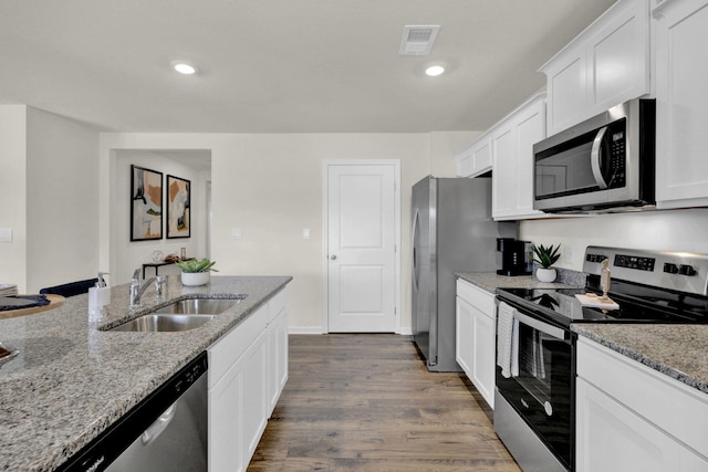 kitchen featuring sink, stainless steel appliances, light stone counters, white cabinets, and dark hardwood / wood-style flooring