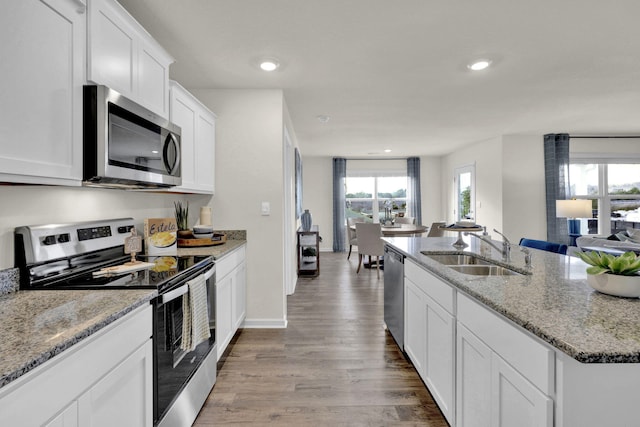 kitchen featuring sink, light hardwood / wood-style flooring, appliances with stainless steel finishes, light stone countertops, and white cabinets