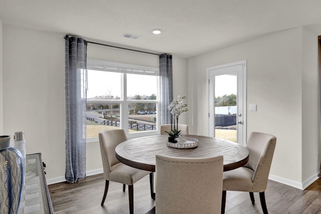 dining space with a healthy amount of sunlight and dark hardwood / wood-style flooring