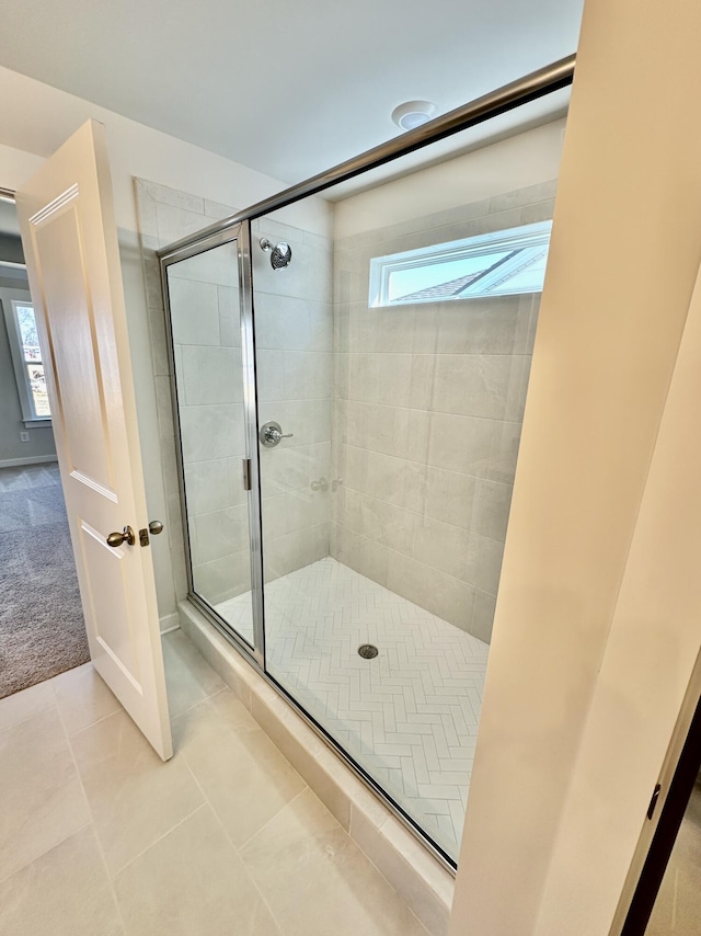 full bathroom featuring tile patterned flooring and a shower stall