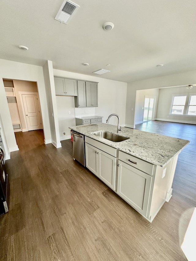 kitchen featuring visible vents, dark wood-type flooring, a center island with sink, a sink, and stainless steel dishwasher