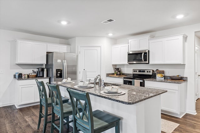 kitchen featuring appliances with stainless steel finishes, a breakfast bar, sink, white cabinets, and a center island with sink