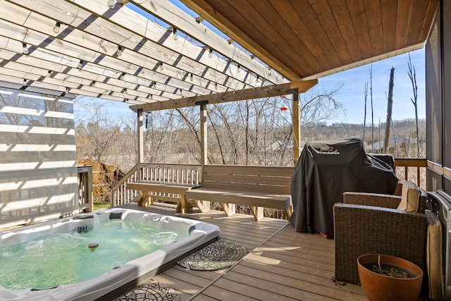 wooden deck featuring area for grilling, an outdoor hot tub, and a pergola