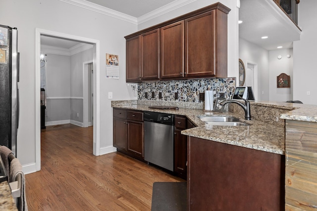 kitchen featuring light stone counters, dishwasher, sink, and hardwood / wood-style floors