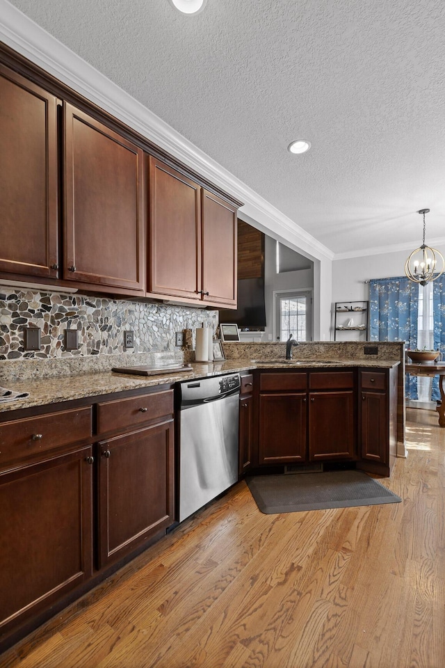 kitchen featuring pendant lighting, dark brown cabinets, stainless steel dishwasher, and light wood-type flooring