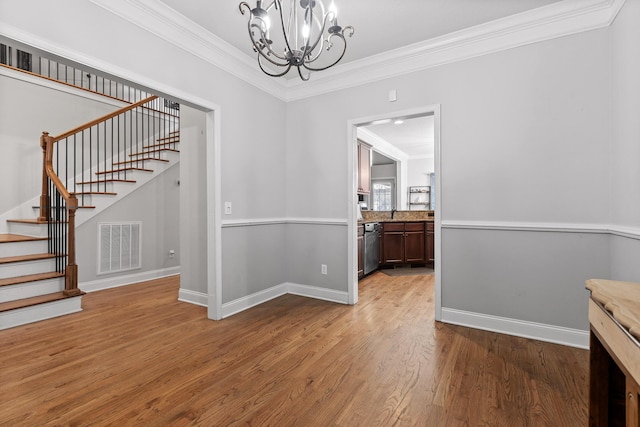 dining room with ornamental molding, a chandelier, and light wood-type flooring