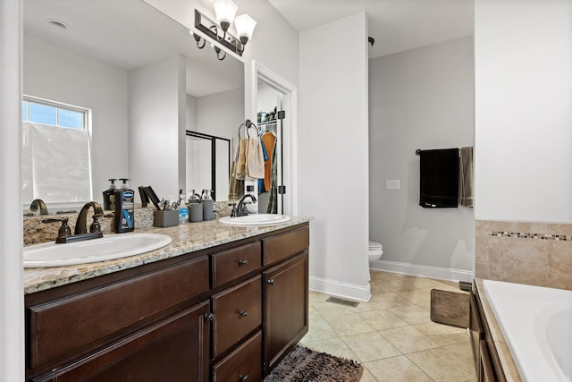 bathroom featuring vanity, a washtub, tile patterned floors, and toilet