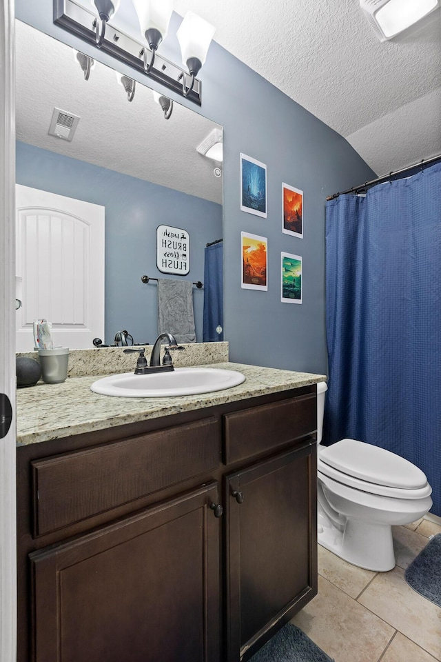 bathroom with vanity, tile patterned floors, toilet, and a textured ceiling