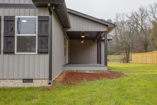 doorway to property featuring ceiling fan and a lawn