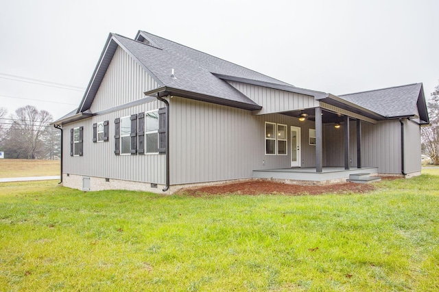 back of property featuring a yard and ceiling fan