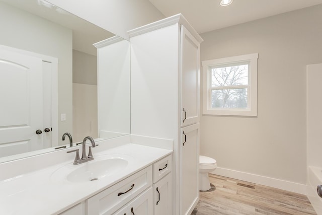 bathroom with wood-type flooring, toilet, and vanity