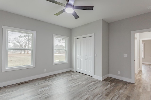 unfurnished bedroom featuring light hardwood / wood-style flooring, a closet, and ceiling fan