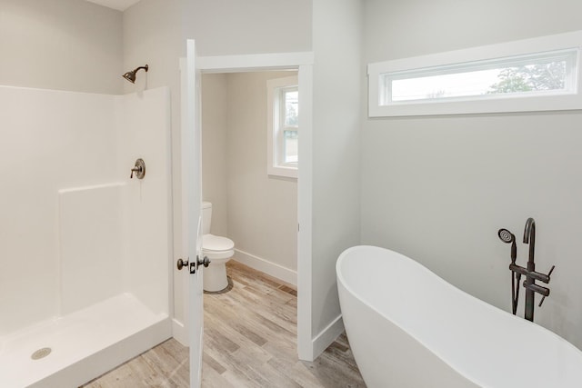 bathroom featuring hardwood / wood-style floors, shower with separate bathtub, and toilet